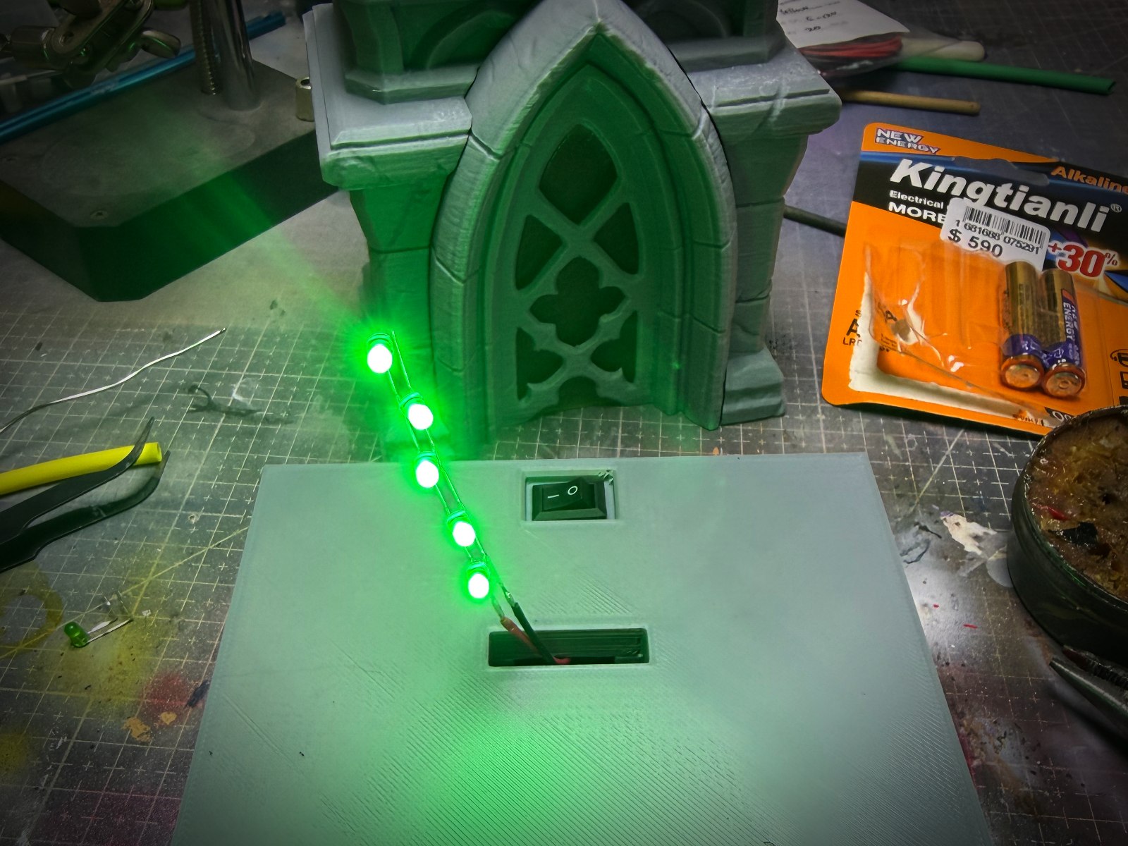 Base de una figura impresa en 3D iluminada en la mesa del taller.